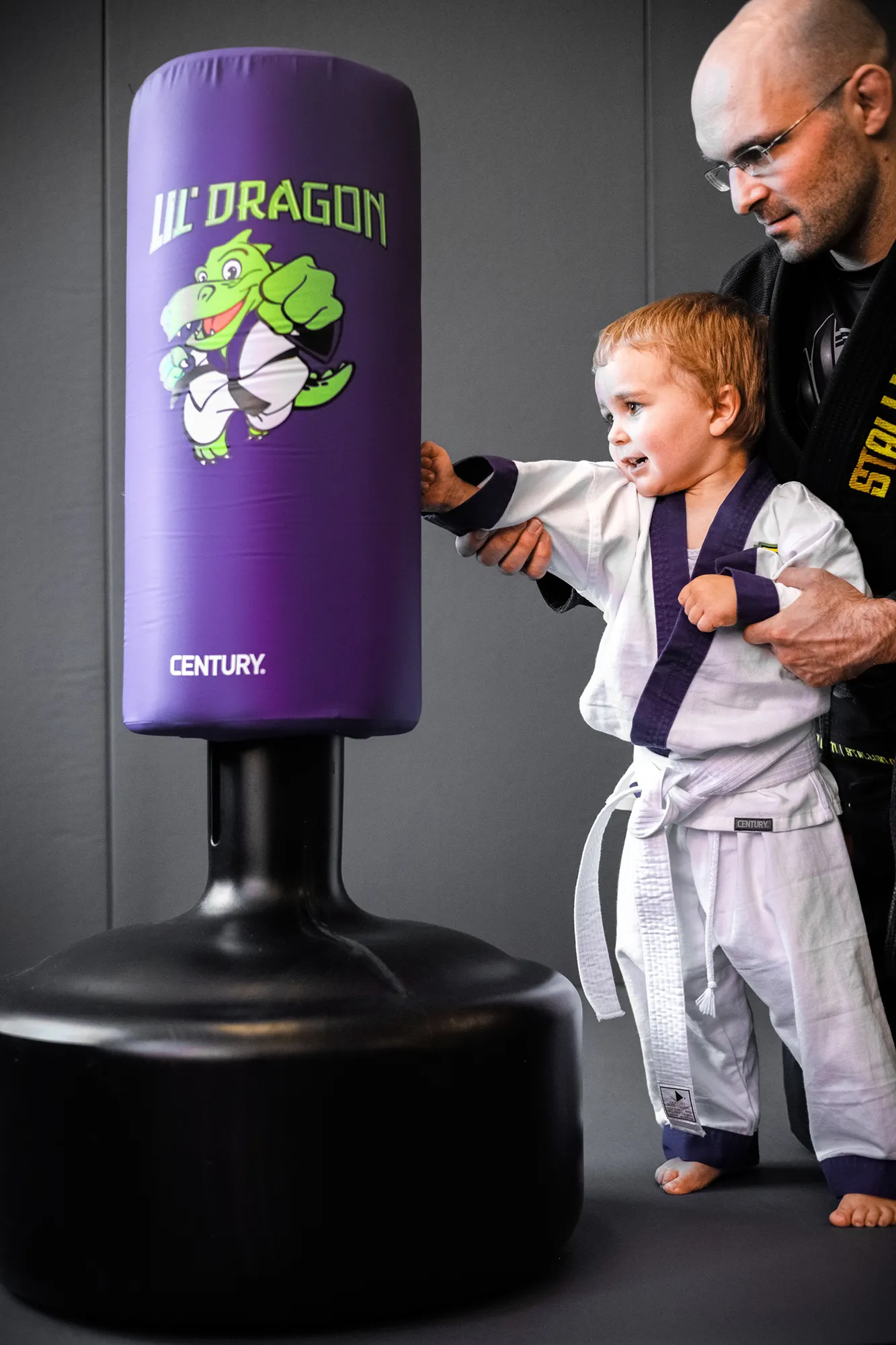 Kind am Lil' Dragon Sandsack mit Trainer