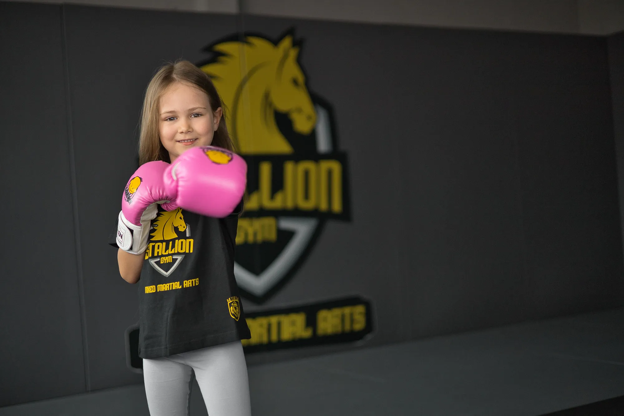 Mädchen mit pinken Boxhandschuhen beim Kickboxen-Training