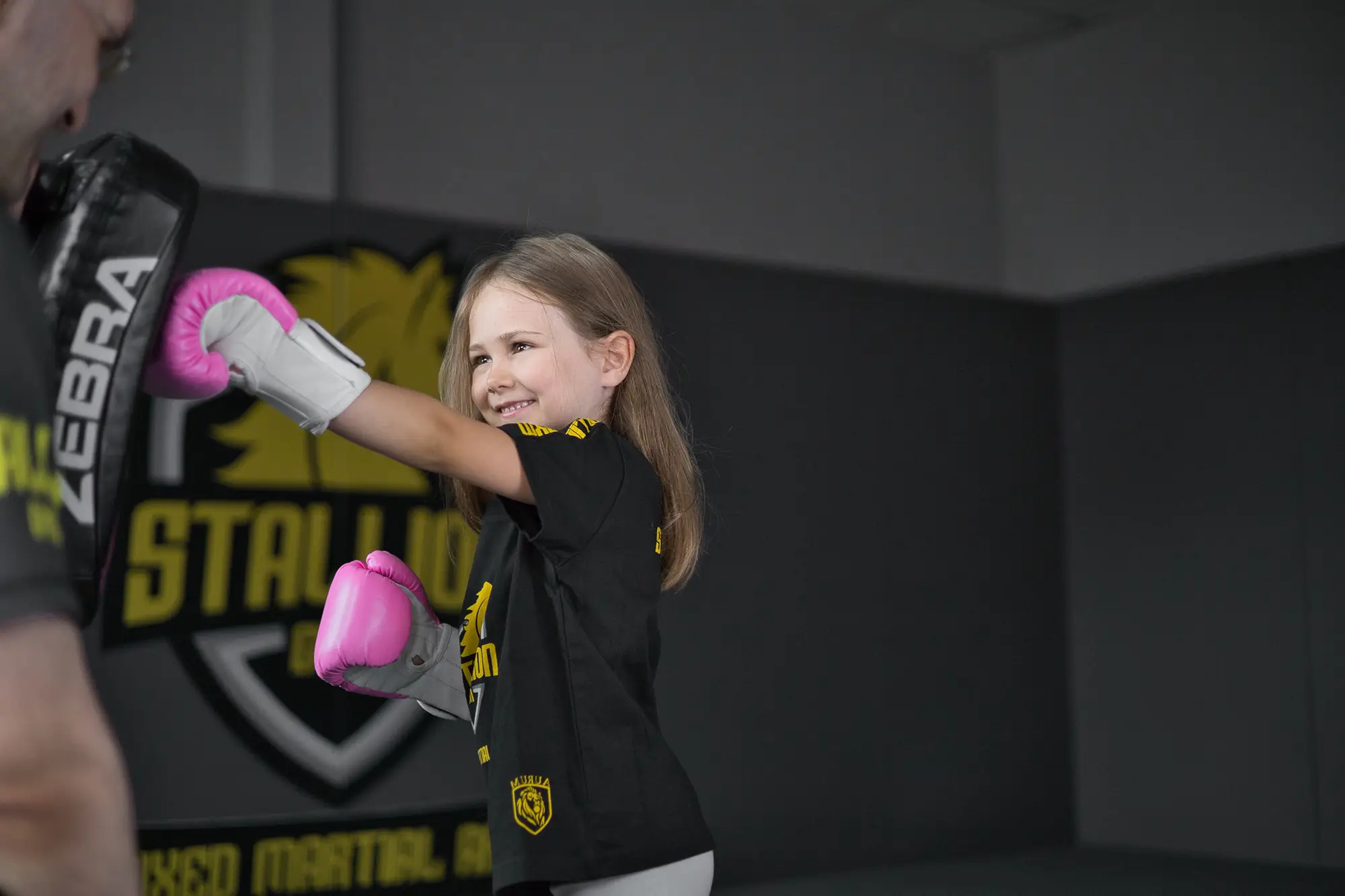 Mädchen mit pinken Handschuhen schlägt