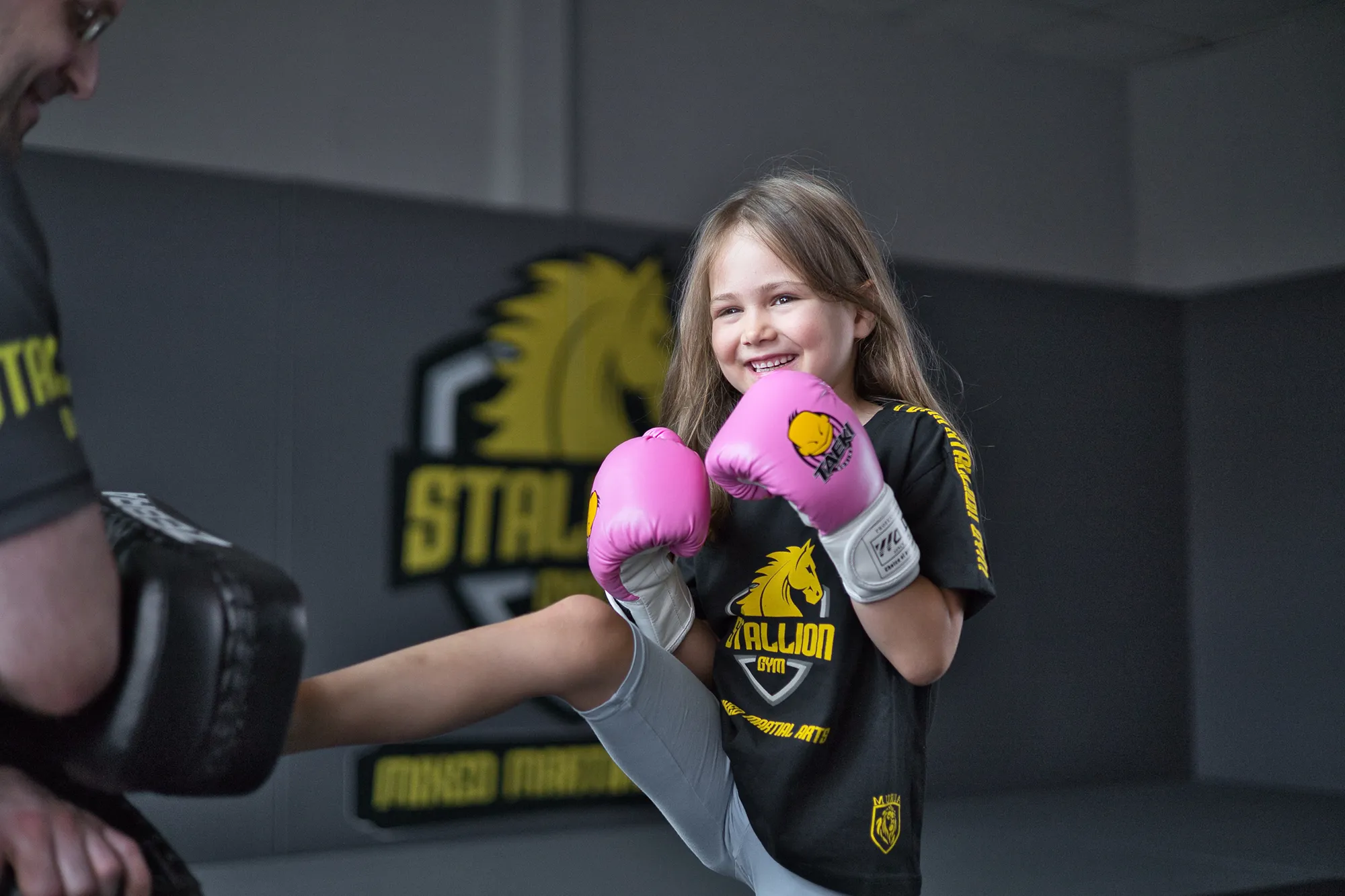 Mädchen beim Kickboxen, lachend mid-kick